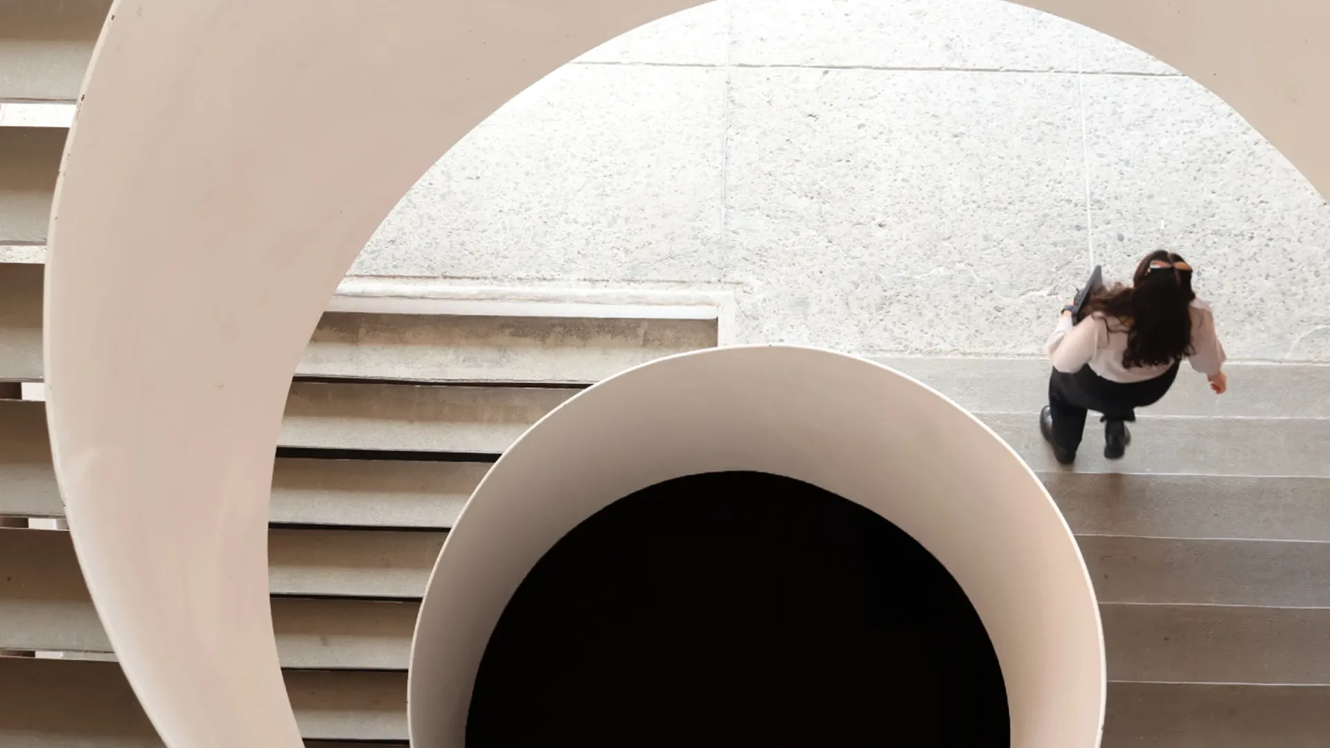 Alumna bajando las escaleras del edificio R en la IBERO.
