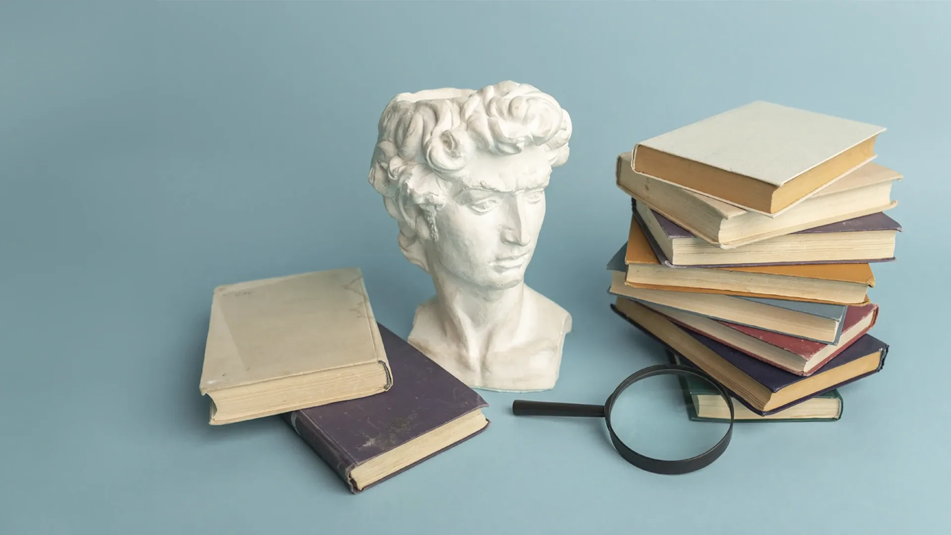  Libros organizados junto a un busto de cerámica.