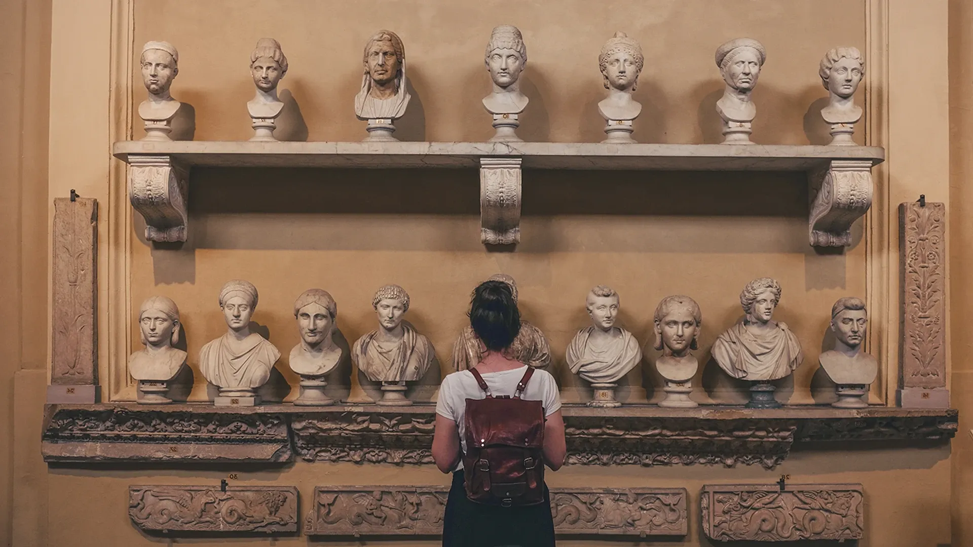  Pesona admirando piezas de arte romano montadas en una exhibición.