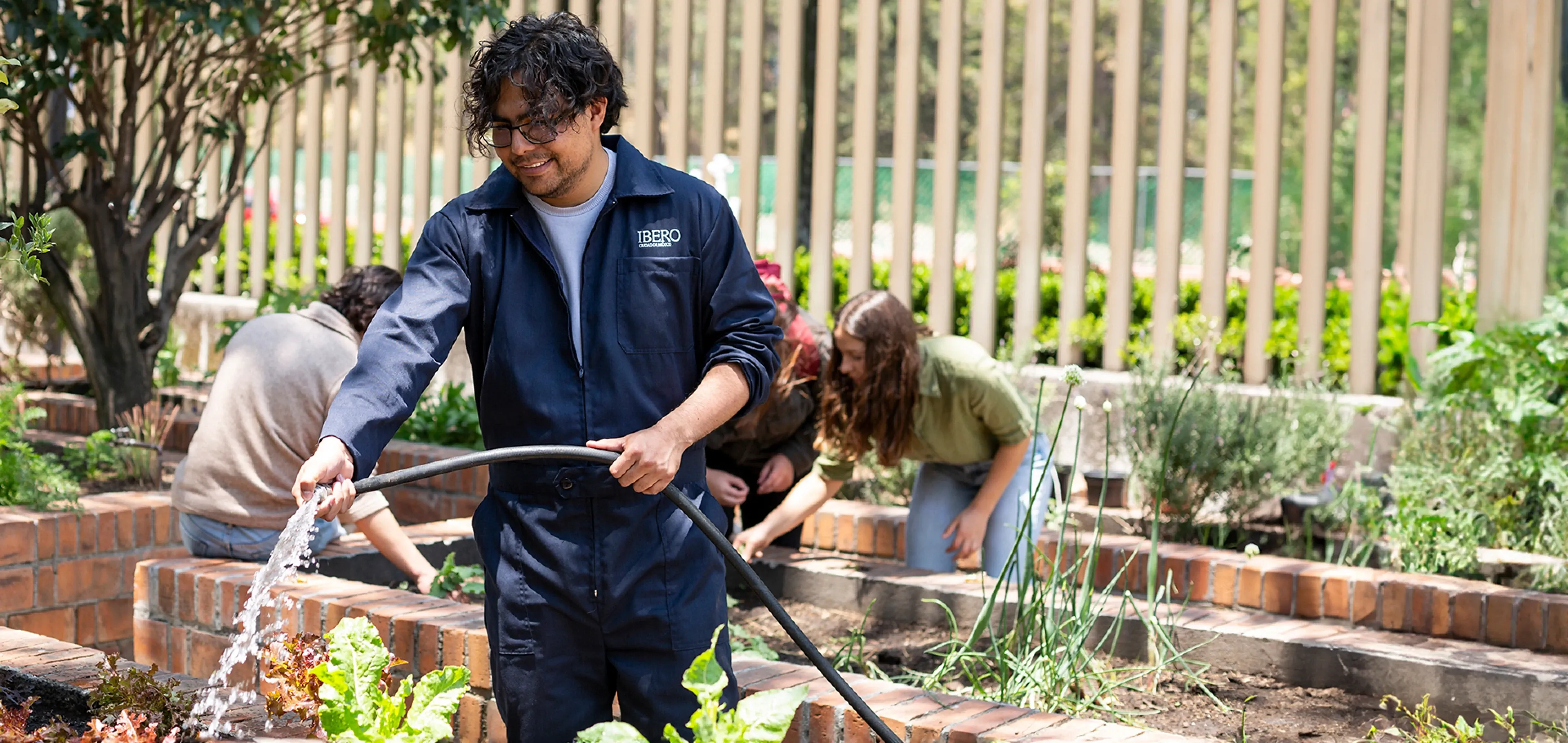 Alumnos regando las plantas en el Huerto IBERO.
